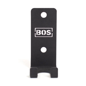 Bells of Steel Hanging Barbell Holders: black metal wall hooks with two mounting holes, designed for secure barbell storage. "BOS" logo in a white rectangle on the front, shown against a white background.