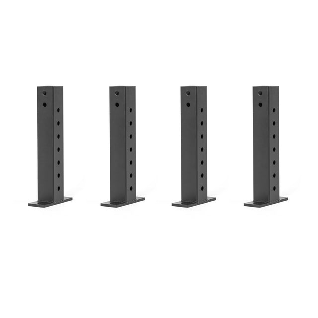 Four black metal Folding Rack Wall Connectors & Hinges from Bells of Steel, each tall and rectangular with circular holes, are arranged in a row on a white background, resembling the sturdy framework of a power rack.