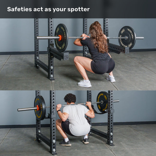 Two people perform barbell squats inside the Bells of Steel Manticore Four Post Power Rack Builder (3" x 3", 1" Holes), highlighting how the safety bars function as spotters. The text at the top states, "Safeties act as your spotter." This setup allows you to lift confidently in your home gym.