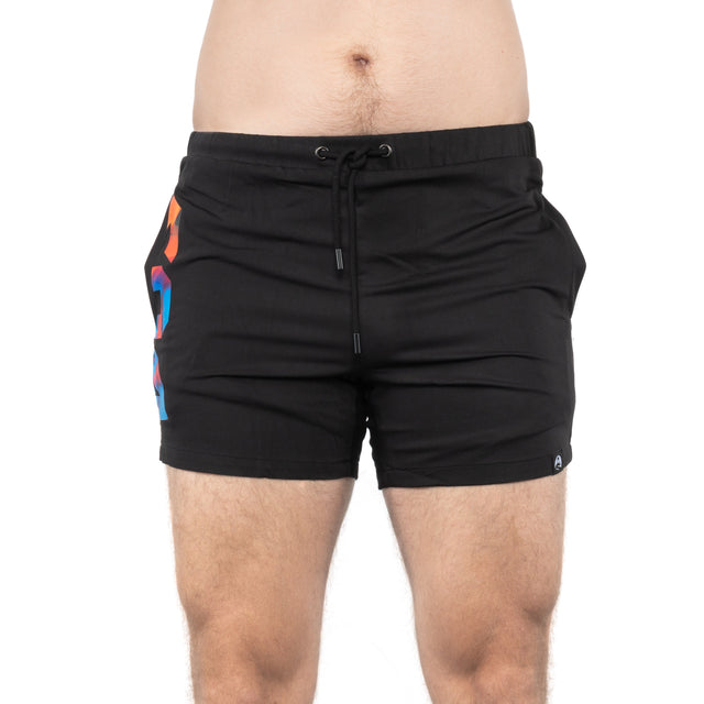 A person wears Bells of Steel Gym Shorts—black, high-performance with a drawstring and colorful accent on the left side—standing against a plain white background. The image is cropped from mid-torso to mid-thigh.