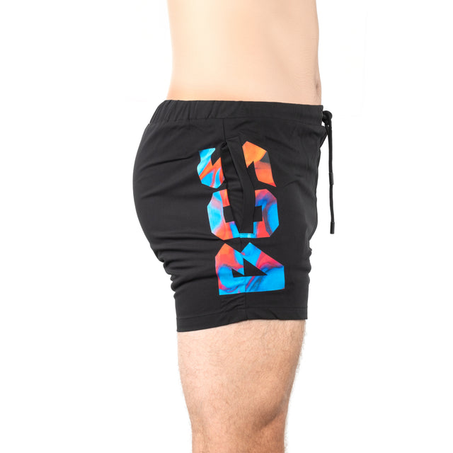 A person wearing Bells of Steel Gym Shorts in black, featuring high-performance fabric and a colorful geometric "98" design on the side, photographed waist down in profile against a white background.