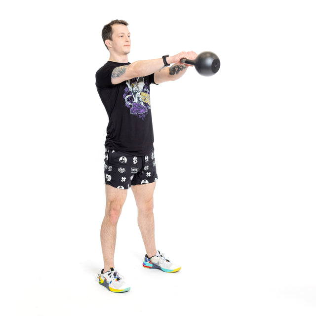 A person in Bells of Steel Gym Shorts, a black t-shirt, and colorful sneakers performs a kettlebell swing at chest height with both hands against a plain white background.