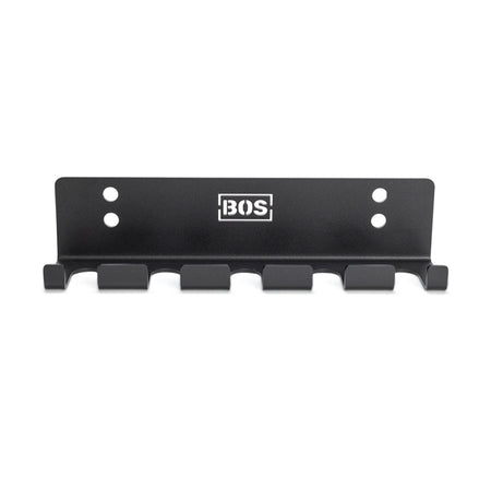 The Bells of Steel Hanging Barbell Holders is a black metal wall rack with six hooks, four screw holes for secure mounting, and a white BOS logo at the center—perfect for organizing your lifting space in style.
