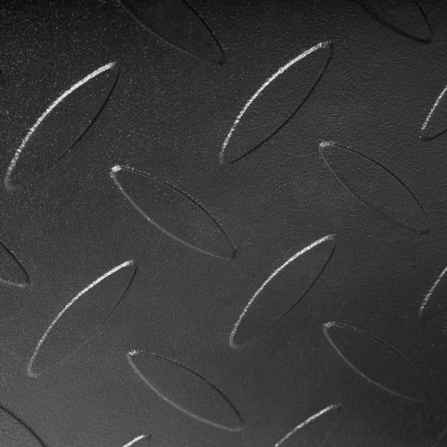 Close-up of a black metal Bells of Steel USA Footplate for Cable Tower/All In One Trainer, featuring a raised diamond plate pattern with repeating oval-shaped textured bumps.