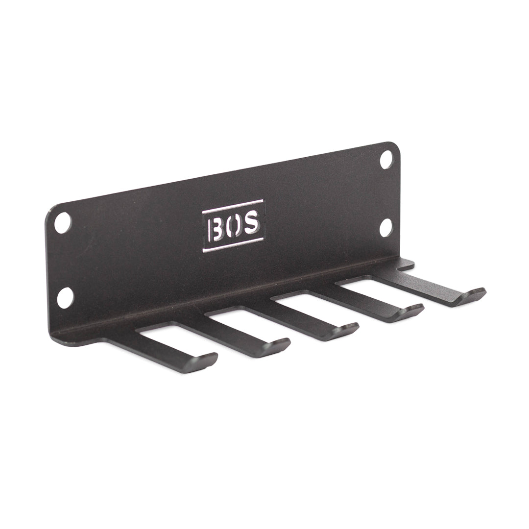 The Bells of Steel Accessory Holder (Wall or Hydra Mounted) is a black metal organizer with four hooks, four screw holes, and "BOS" cut out in the center—perfect for storing Hydra rack accessories in your gym.