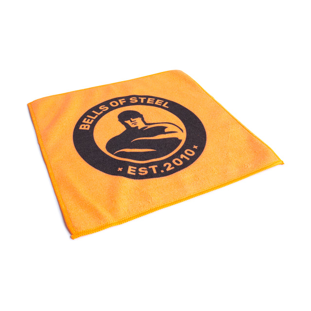 The Bells of Steel Barbell Cleaning Microfiber Cloth is an orange, lint-free towel with a black circular logo showing a muscular figure and the text "BELLS OF STEEL EST. 2010.