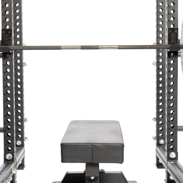 A close-up of a Bells of Steel power rack shows a weight bench, barbell, and Standard J-Cups with UHMW protection and numbered holes for easy height adjustment.