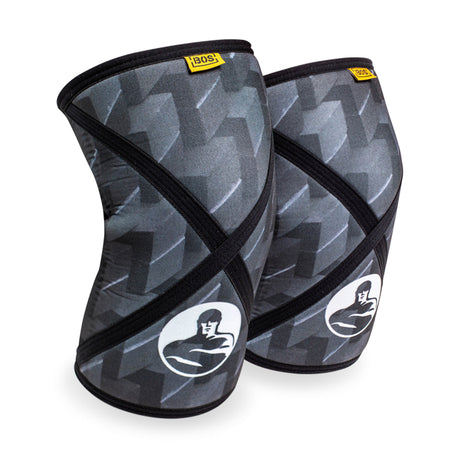 Bells of Steel Knee Sleeves in black and gray feature a muscular figure logo and yellow label, offering a contoured design for effective squat support.