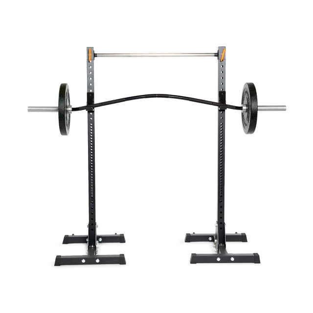A Bells of Steel power rack showcases a Curved Squat Bar loaded with weights. It features adjustable J-hooks and spotter arms designed to reduce joint strain during exercises like squats and bench presses, enhancing muscular development.