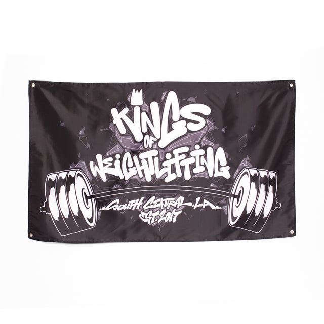 The Bells of Steel Flags feature black fabric with white graffiti text, "Kings of Weightlifting, South Central LA, Est. 2017," and two barbells—ideal for gym decor or as a striking home gym flag.