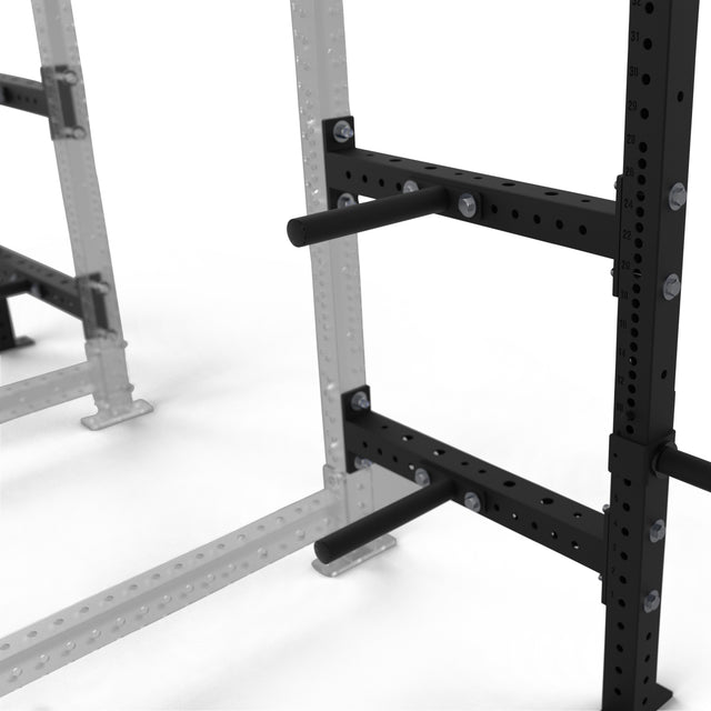 Close-up of the Bells of Steel Hydra Batwing Storage, a black and silver modular gym rack featuring horizontal weight plate storage pegs attached to the frame. The focus is on the rack's storage hardware, with a slightly blurred background.
