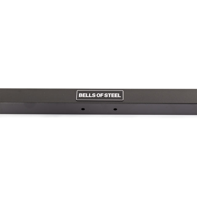 A close-up of the Bells of Steel Cable Crossover (2.3" x 2.3" Racks) shows a black metal bar with a white "BELLS OF STEEL" label and two small holes beneath it, set against a white background.