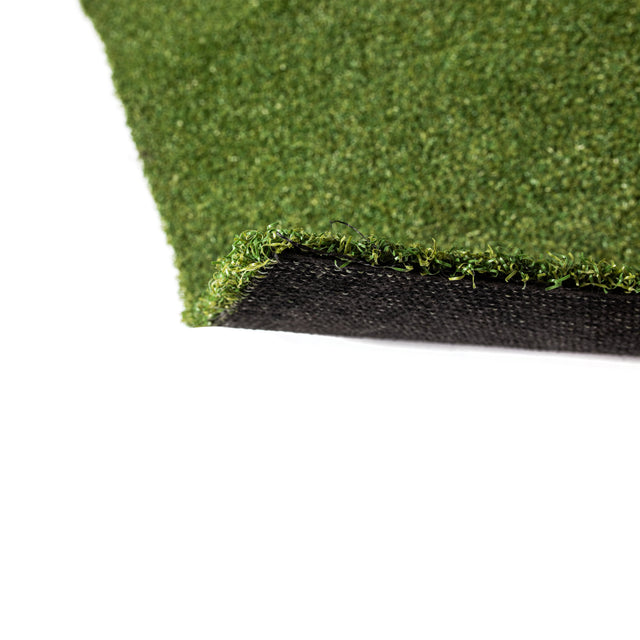 A close-up of Bells of Steel's Roll of Gym Turf, featuring short green synthetic fibers and visible black backing, shown from an angled edge on a white background—perfect for gym or sled training setups.