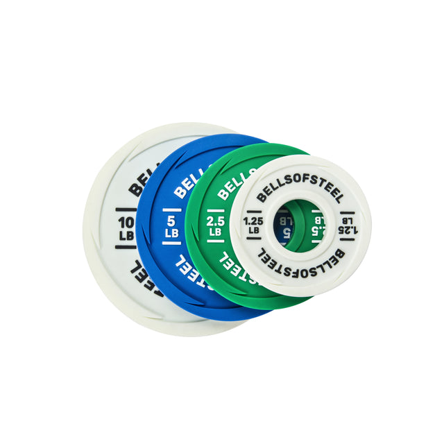 Four Bells of Steel Urethane-Coated Change Plate Sets in white, blue, green, and white are fanned out, with weights of 10 lb, 5 lb, 2.5 lb, and 1.25 lb shown from largest to smallest.