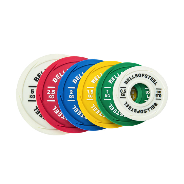 The Bells of Steel Urethane-Coated Change Plate Sets include six colorful, durable plates: white (0.5 kg), red (2.5 kg), blue (2 kg), yellow (1.5 kg), and green (1 kg), each labeled and arranged side by side.