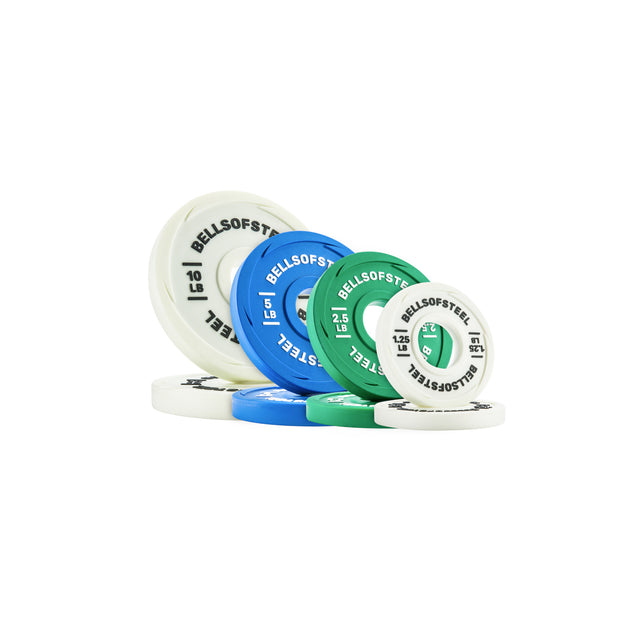 A stack and spread of white, blue, and green Urethane-Coated Change Plates from Bells of Steel, with the brand logo printed on them, arranged on a white background and resembling colorful poker chips.