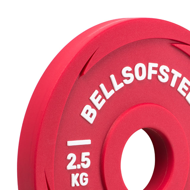 A close-up of a Bells of Steel Urethane-Coated Change Plate Set in red, featuring white "BELLSOFSTEEL" and "2.5 KG" text engraved on its smooth surface, with a center hole for easy barbell mounting—perfect as training plates.