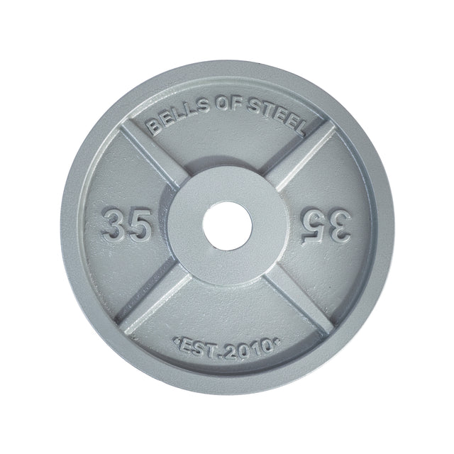 A Machined Iron Olympic Weight Plate from Bells of Steel, seen from above, is gray with "BELLS OF STEEL," "35," and "EST. 2010" engraved, plus a precision hole fit and four raised sections forming an X shape.