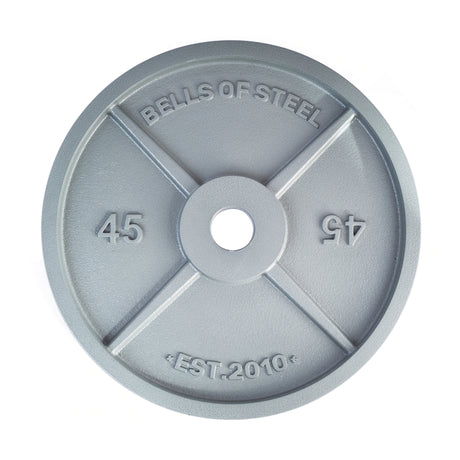 A gray, circular 45-pound Machined Iron Olympic Weight Plate by Bells of Steel, embossed with "BELLS OF STEEL" and "EST. 2010," features a precision barbell hole and the number 45 on both sides.