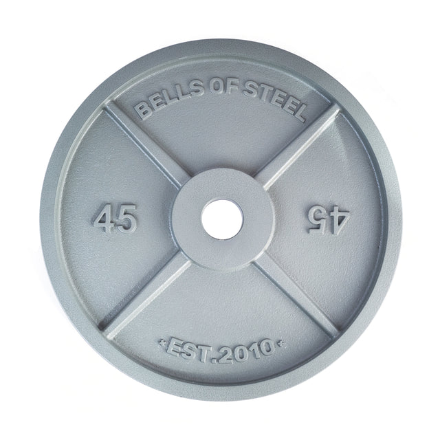 A gray, circular 45-pound Machined Iron Olympic Weight Plate by Bells of Steel, embossed with "BELLS OF STEEL" and "EST. 2010," features a precision barbell hole and the number 45 on both sides.