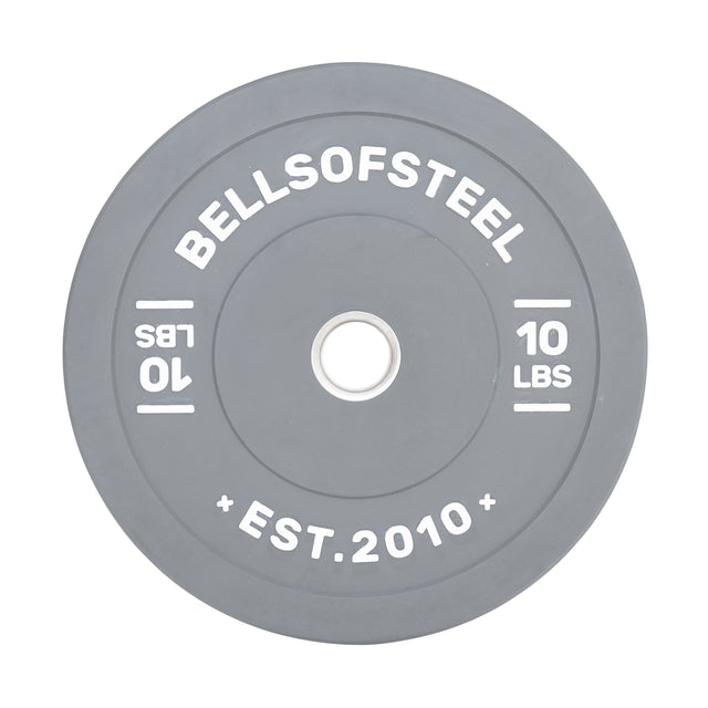 The Bells of Steel Colored Bumper Plates include a grey round design with "BELLSOFSTEEL" and "10 LBS" inscribed, plus "EST. 2010" at the bottom. Its stainless steel insert ensures accurate weight and a perfect fit on barbells.