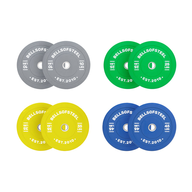 The Bells of Steel Colored Bumper Plate Sets include four pairs—gray (10 lbs), green (25 lbs), yellow (35 lbs), and blue (45 lbs)—all with stainless steel inserts, "BELLSOFSTEEL EST. 2010" labels, and accurate weight for every lift.