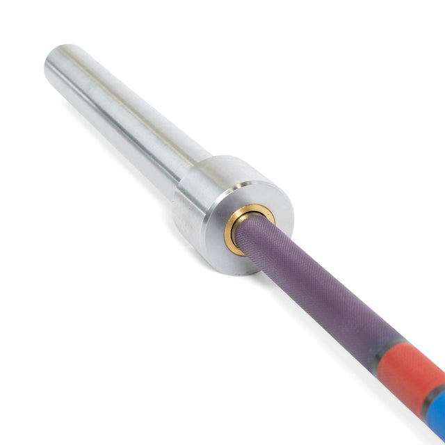 A close-up of the Bells of Steel Hydra Seven Ring Bar shows its silver sleeve, gold ring at the joint, and textured purple shaft with red and blue end markings—ideal for heavy lifts with a 2000lb capacity.
