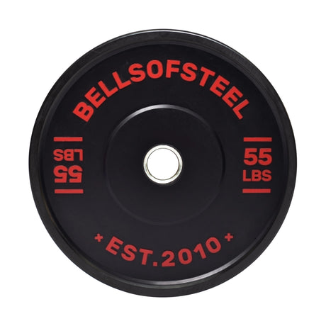 The Dead Bounce Conflict Bumper Plate by Bells of Steel is black with red text displaying "BELLS OF STEEL" and "55 LBS." and notes "EST. 2010" at the bottom. Made from virgin rubber, it features a durable stainless steel center insert.