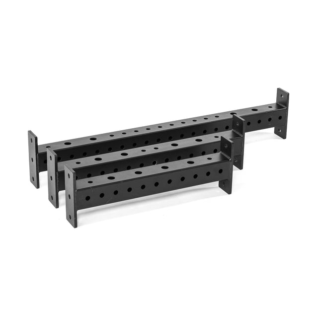 Three black rectangular Hydra Crossmembers by Bells of Steel, each with multiple evenly spaced round holes and anchored plates at both ends, are stacked together.