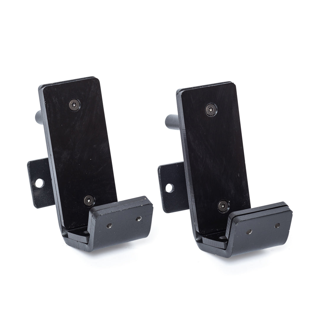 Two black metal wall hooks—Standard J-Cups by Bells of Steel—with rectangular backplates, angled supports, two screw holes for mounting, and a protruding bottom section for hanging items.