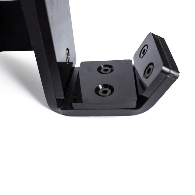 Close-up of Bells of Steel Standard J-Cups, black metal with three screw holes, shown on a white background. The L-shaped design with flat base and upright section is ideal for power racks needing UHMW protection.