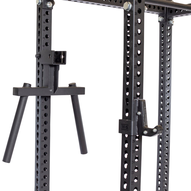 Close-up of the Bells of Steel Y Dip Bar Rack Attachment in black steel, with vertical posts and multiple holes. Two horizontal pegs protrude for versatile strength training. The heavy-duty attachment includes hooks and bolts for secure setups.