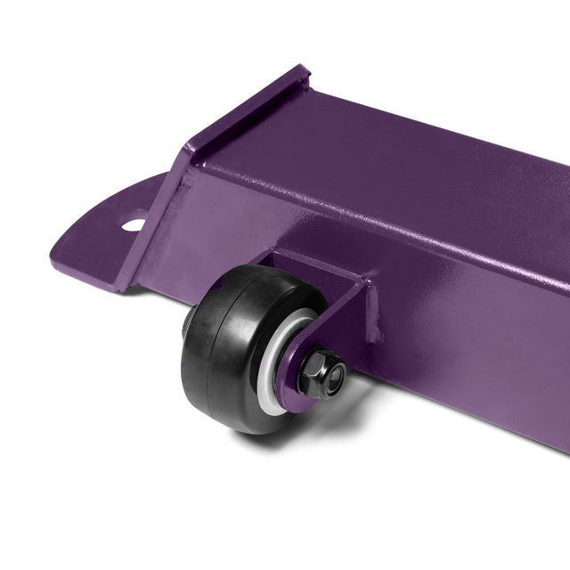 The Buzz-Saw Heavy-Duty Adjustable Bench by Bells of Steel features a sturdy close-up purple metal component with a small black wheel mounted on an axle for smooth rotation, ensuring stability with its flat base, vertical side, and rounded corner for heavy-duty applications.