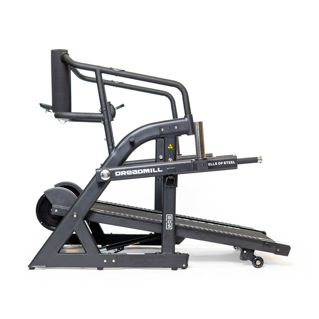 Side view of a black Bells of Steel's The Dreadmill, highlighting its robust build and curved track for intense cardio. It features extra handles for support and stands sleekly against a white background.