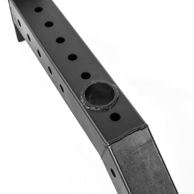 A close-up of Bells of Steel Front Foot Stabilizers shows a black metal bar with evenly spaced round holes and a circular weld, ideal for enhancing power rack stability, set against a white background.