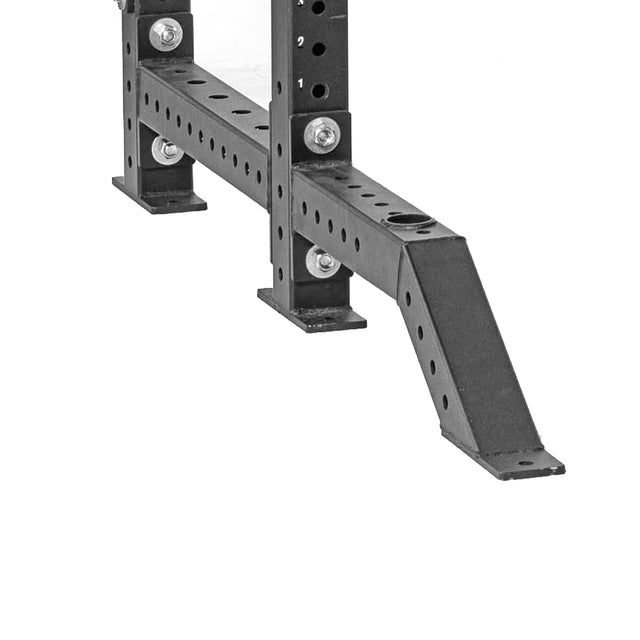 A close-up of Bells of Steel Front Foot Stabilizers—black metal accessories with multiple holes for adjustable attachments, barbell storage options, and a diagonal support brace for stability—shown against a white background.