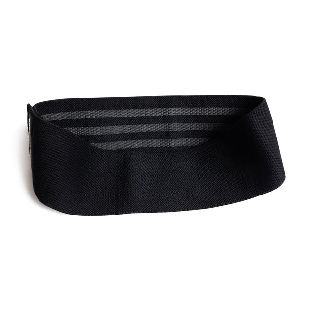 The Bells of Steel Glute Loop is a black, wide resistance band with horizontal stripes, curved in an open loop and resting on a white background—perfect for your next booty workout.