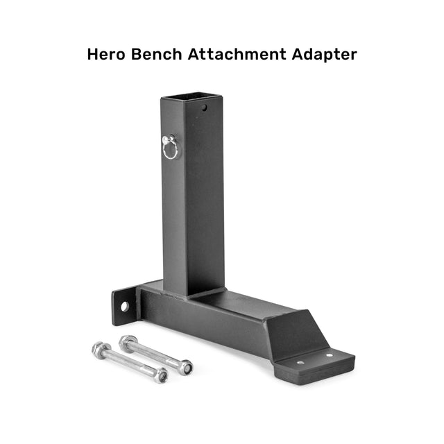 A black metal Bench Attachments adapter with two bolts and nuts from Bells of Steel is displayed on a white background with the text "Hero Bench Attachment Adapter for Leg Extensions" elegantly placed above.