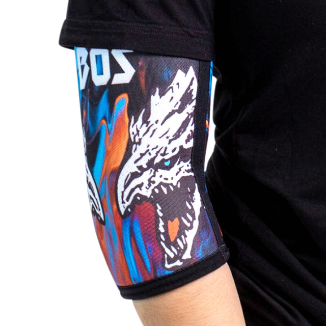 A close-up of an arm in Bells of Steel Elbow Sleeves, featuring a vibrant white dragon head design on an abstract background. The wearer is dressed in a black shirt.