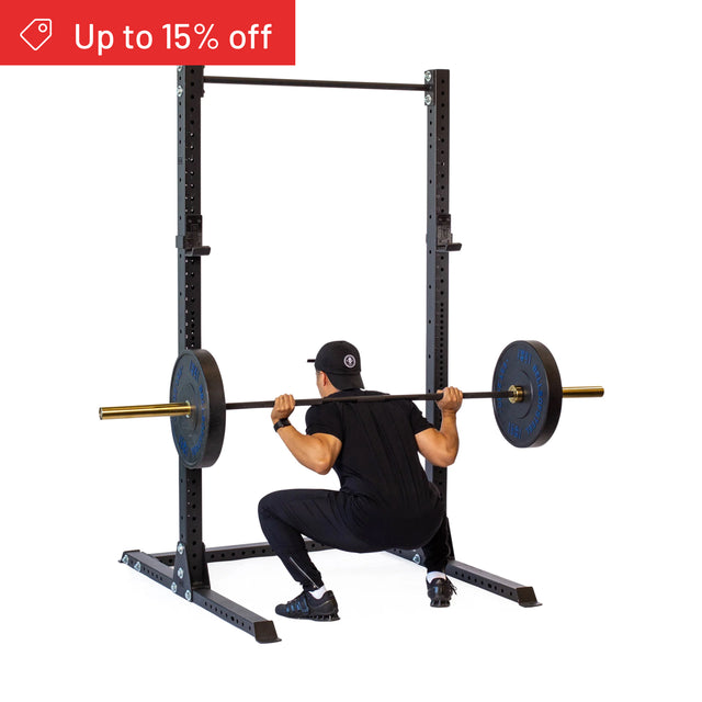 A person in black workout gear is squatting with a barbell on the Bells of Steel Hydra Squat Stand Builder (3" x 3", ⅝" Holes), with a red "Up to 15% off" banner. White background. Ideal for upgrading your home gym setup.