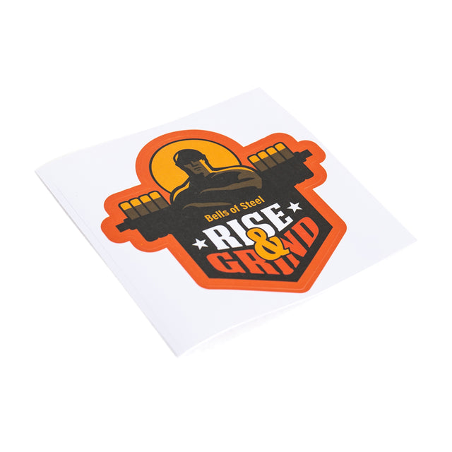 A square, durable Bells of Steel sticker shows a muscular figure lifting a barbell, with "RISE & GRIND" in bold orange, yellow, and white on a vivid black and orange background.