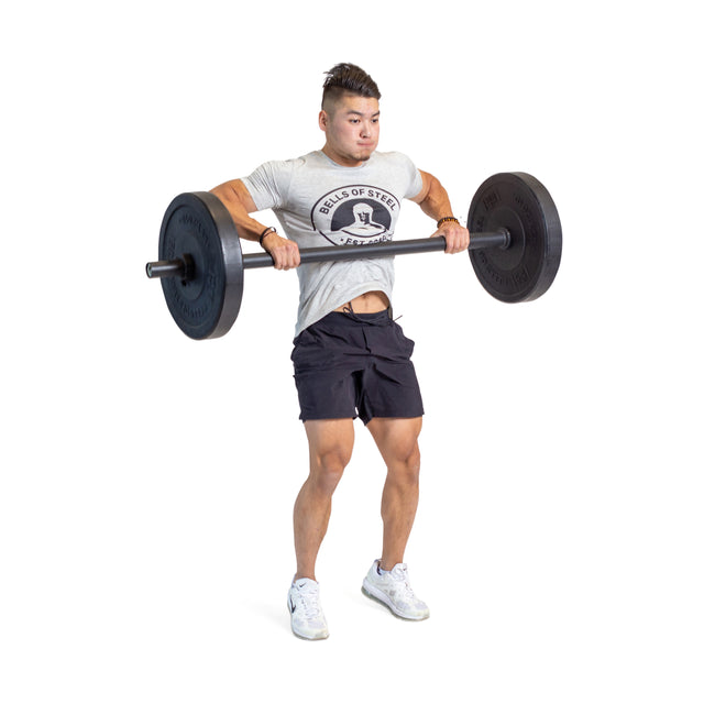 A man demonstrates grip strength by performing an upright row with Bells of Steel Axle Bars, wearing a gray T-shirt and black shorts against a white background—a classic strongman training move.