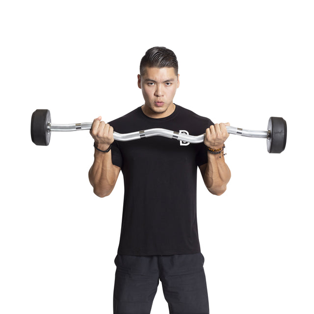 Wearing a black t-shirt, a person lifts Bells of Steel's Fixed Barbells - Easy Curl against a white background, concentrating on the workout—ideal for any home gym.