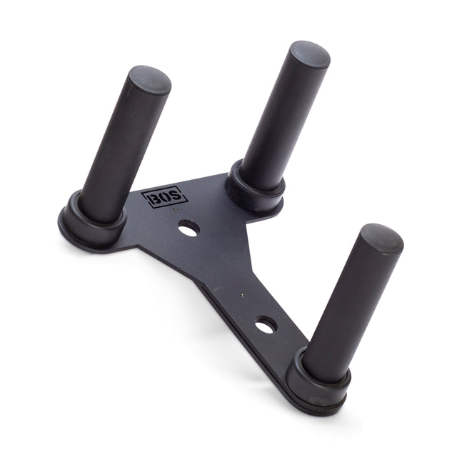The Bells of Steel Change Plate Storage Pegs is a sleek, black triangular stand with three cylindrical posts displaying an "IQS" logo, designed to hold items like Olympic change plates. It stands out against a plain white background.