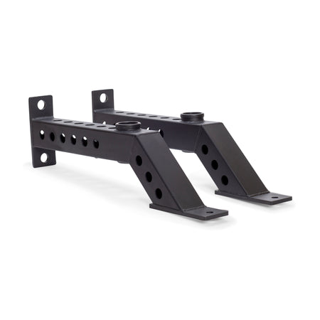 The Bells of Steel Front Foot Stabilizers are two black metal brackets with multiple holes, angled sections, and flat mounting plates at both ends, designed to add support or enable barbell storage on your power rack.