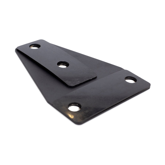 The Manticore Flat Foot Components by Bells of Steel are black metal brackets with two overlapping sections, each having two mounting holes, designed to integrate seamlessly with Manticore power racks against a white background for a sleek look.
