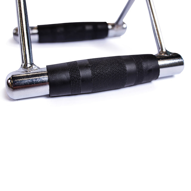 Close-up of the Bells of Steel Double D Handle Cable Attachment, featuring a chrome finish and textured black rubber grip, resting on a white surface.
