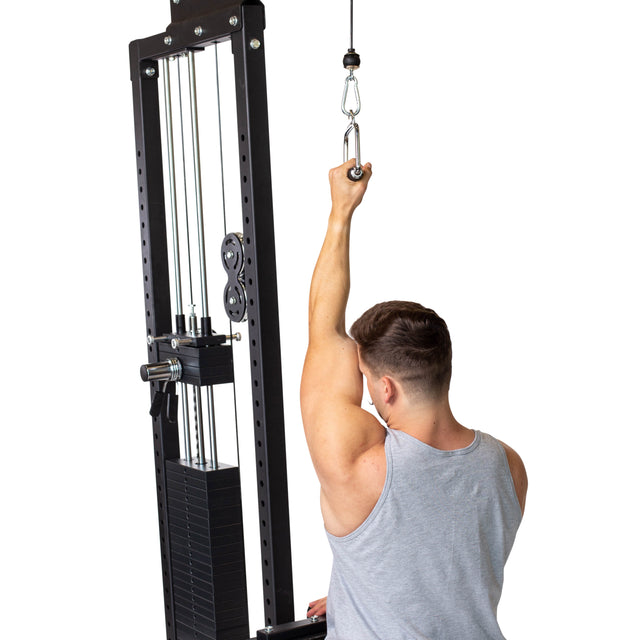 A man in a gray tank top uses a Bells of Steel Single D Handle Cable Attachment, pulling it overhead with one arm. Viewed from behind, his arm and back muscles are highlighted as he grips the cable machine handle.