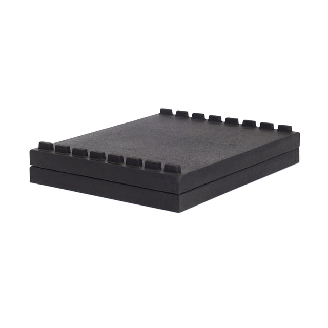 The Bells of Steel Stackable Pull Blocks are black rectangular foam pads with evenly spaced square notches along one edge, designed for lifting blocks in deficit deadlifts or jerk work, shown stacked against a white background.