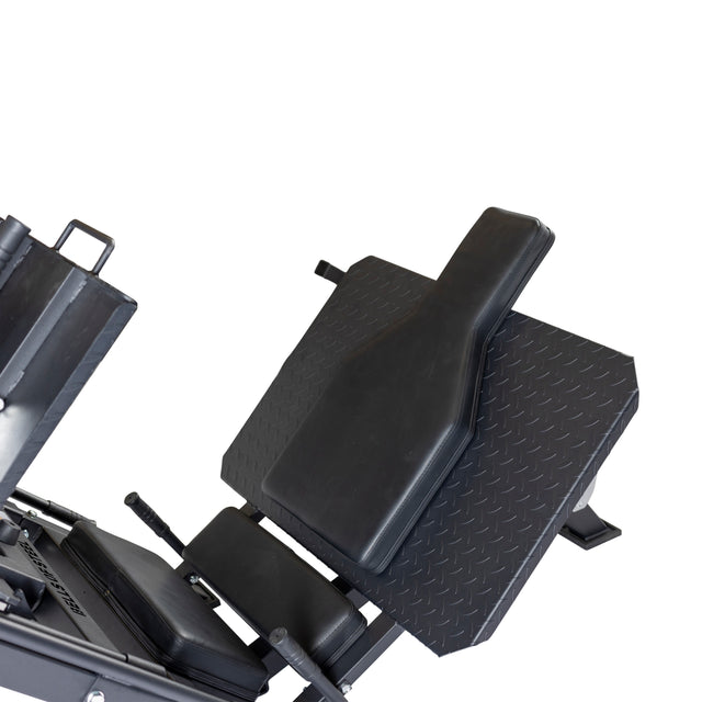 A close-up of the Bells of Steel 2-in-1 Iso Leg Press & Hack Squat Machine (The Juggernaut) features a black frame, cushioned backrest, and footplate, showcased on a white background.